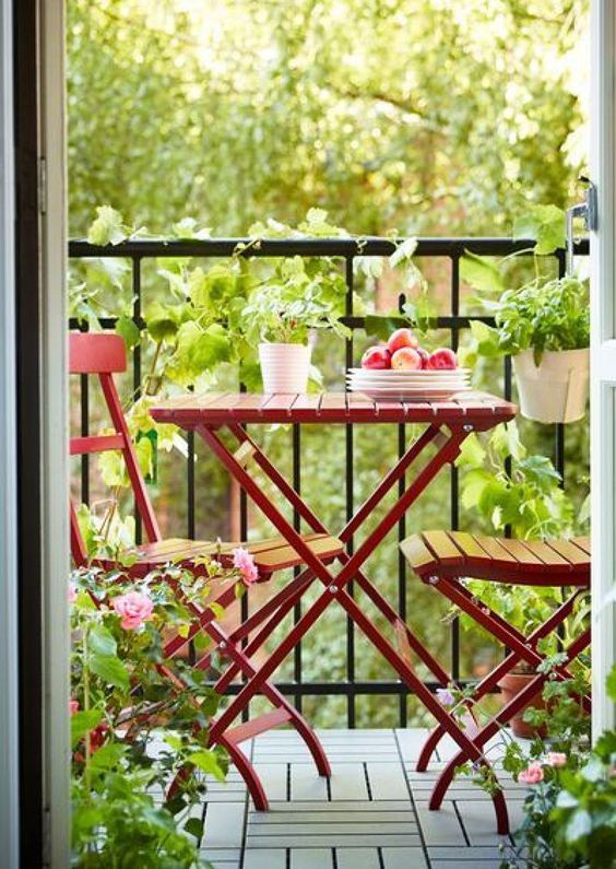 Simple balcony decor with small wooden bistro set and plants