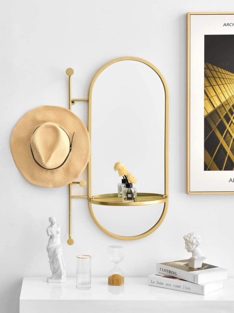 gold oval mirror with shelves and hooks
