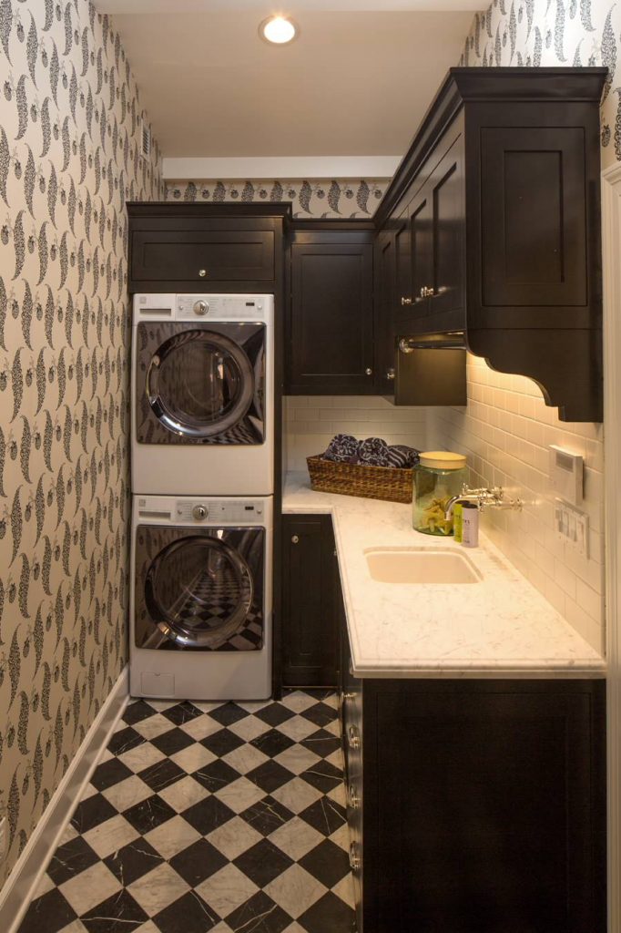small laundry room with black cabinets
