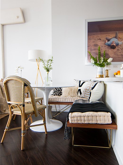 small breakfast nook with wooden bench and rattan chairs