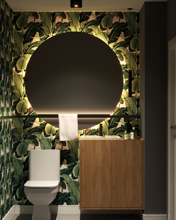 dark powder room with tropical wallpaper
