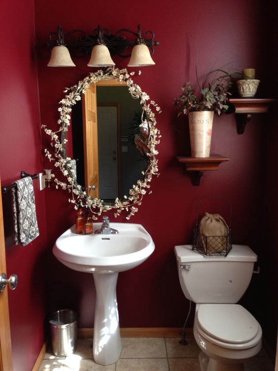 deep red moody bathroom with gold and wooden accents