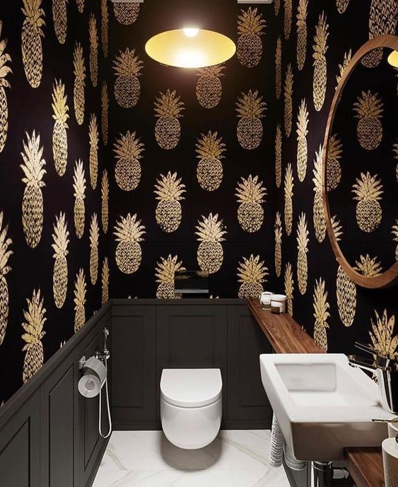 black moody powder room with gold pineapple wallpaper