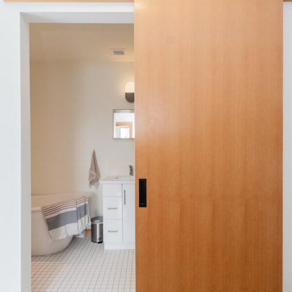 brown wooden door near white ceramic toilet bowl