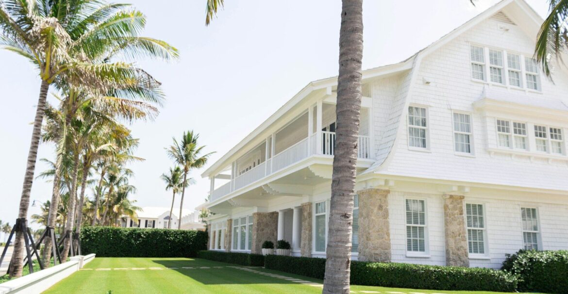 white wooden house near palm trees